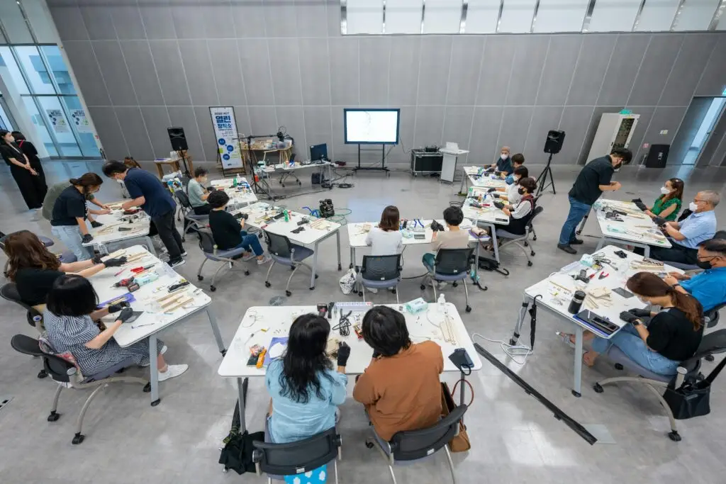 Overhead view of a hands-on classroom workshop with diverse students using hi-tech equipment.